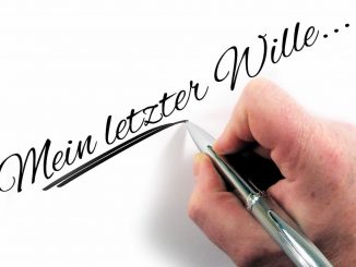 Hand schreibt ein eigenhändiges Testament auf Papier