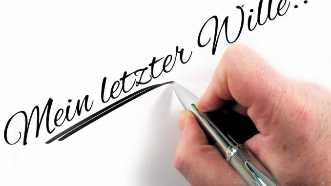 Hand schreibt ein eigenhändiges Testament auf Papier