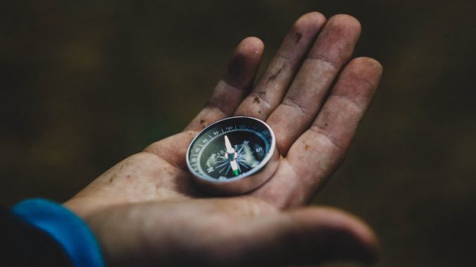 Ältere Person hält in der Hand einen Kompass