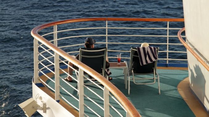 Paar auf dem Sonnendeck eines Kreuzfahrtschiffes/ Erbe oder selber ausgeben Rente